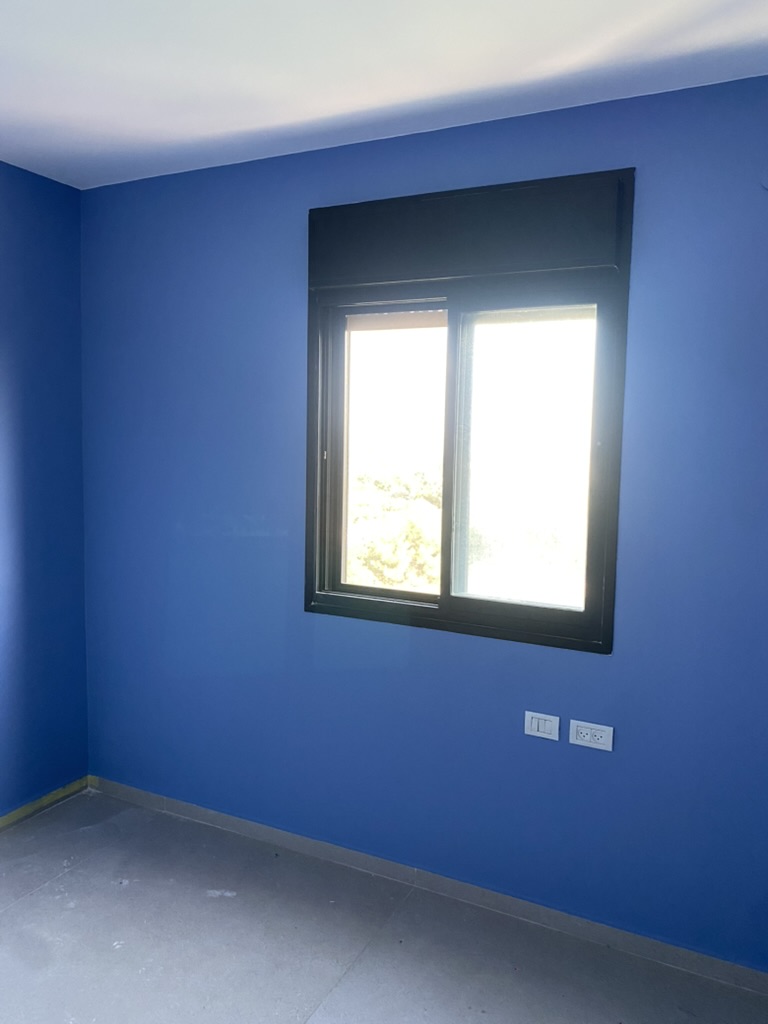 Blue bedroom wall and window after painting