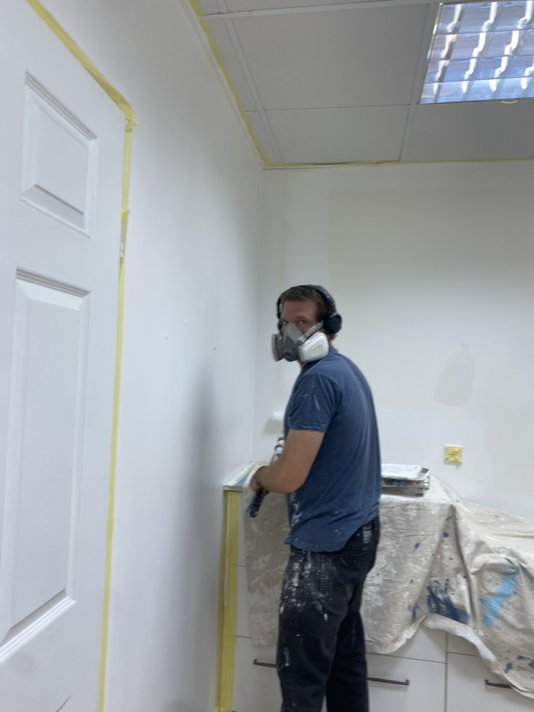 Painter preparing a room for a new finish